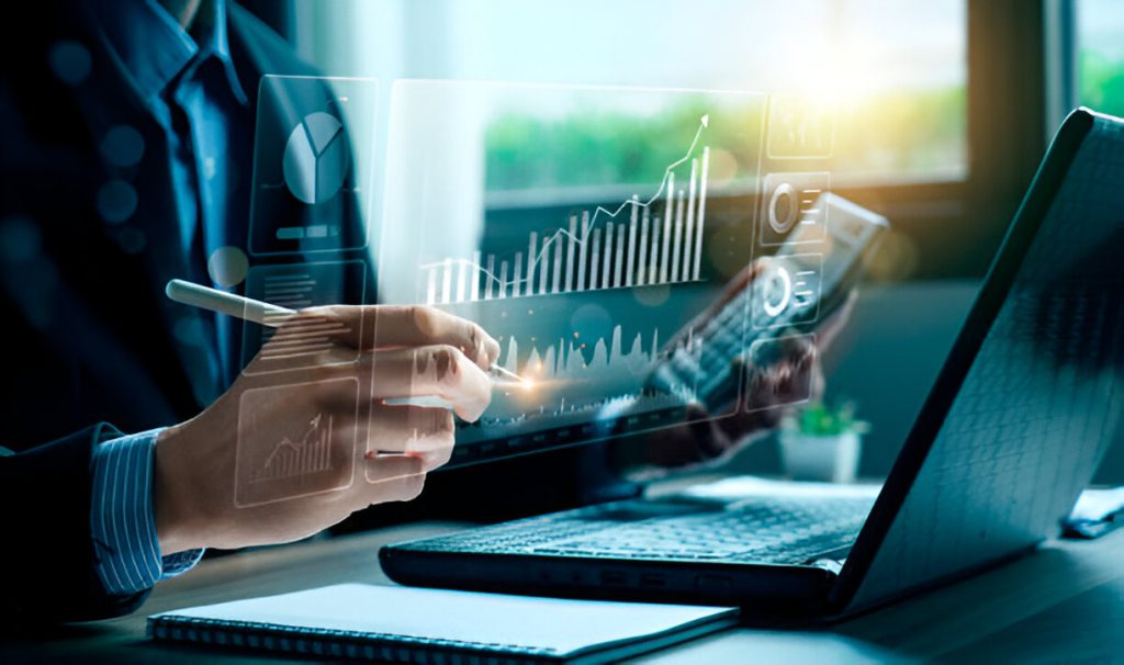 Seorang profesional bisnis menggunakan teknologi digital untuk menganalisis data grafik dan performa penjualan di marketplace, dengan latar belakang layar laptop dan perangkat ponsel.